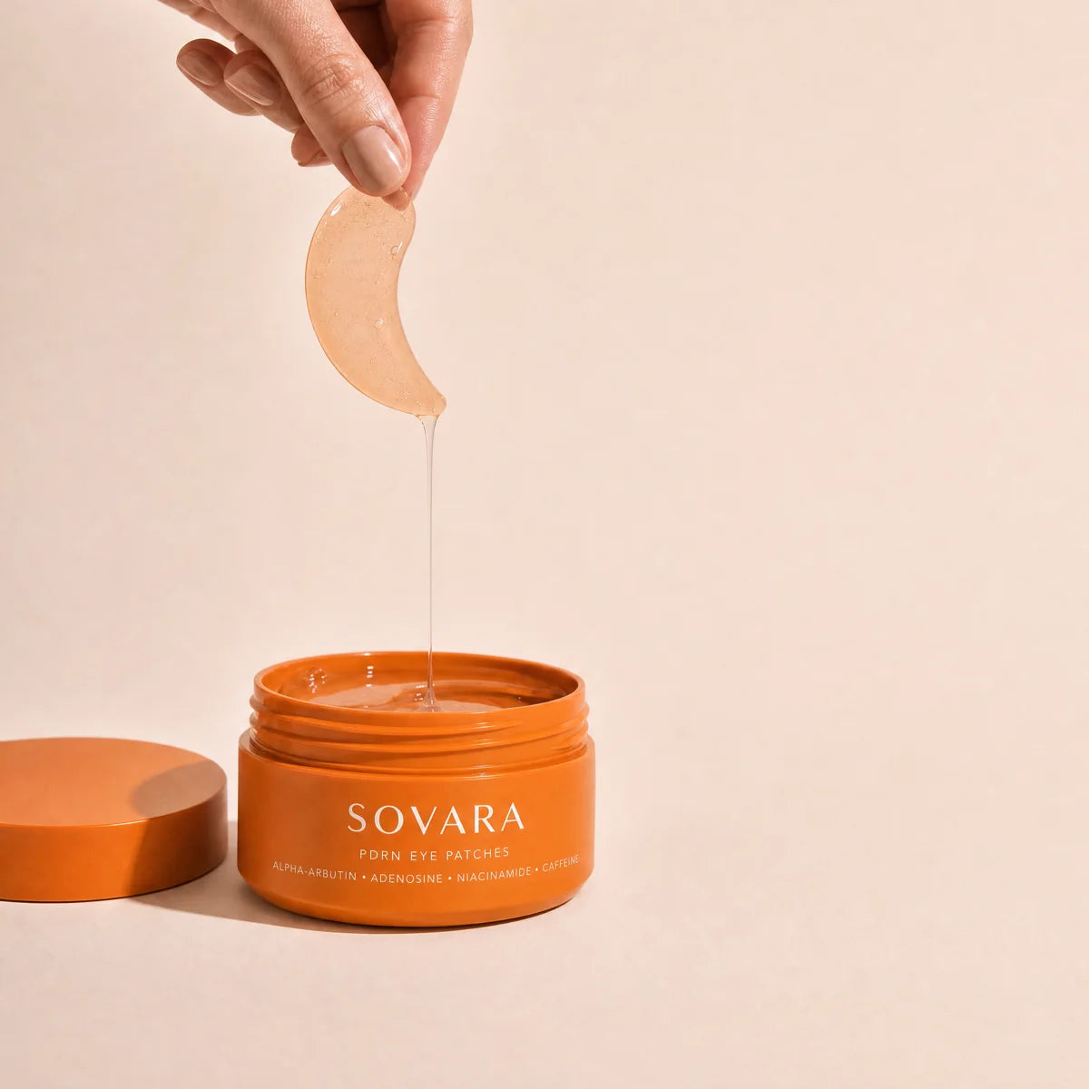 A hand lifting an orange patch out of the Sovara jar